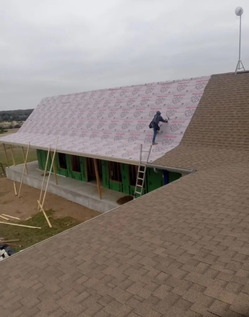 Worker preparing underlayment for a metal roof installation in University of California-Santa Barbara